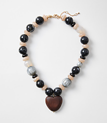 A chunky necklace with a wooden heart pendant rests on a plain white background. carousel Product Image 1