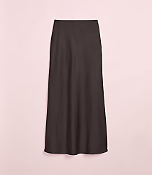 A dark brown, floor-length skirt hangs against a soft pink background. carousel Product Image 4