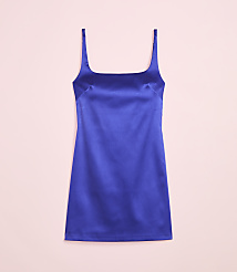 A vibrant blue satin slip dress with thin straps is laid flat against a soft pink background. carousel Product Image 2