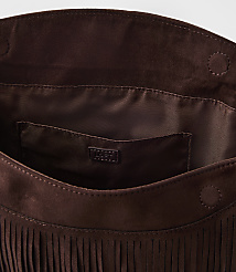 A brown suede fringed clutch with a satin lining and a small logo tag is presented against a plain white background. carousel Product Image 2