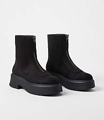 A pair of black, zip-front platform boots rests on a plain white background. carousel Product Image 1