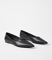 A pair of black pointed-toe flats rests on a plain white background. carousel Product Image 1