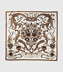 A square silk scarf with an ornate brown floral pattern on a white background is displayed against a plain gray backdrop. carousel Product Image 2