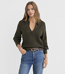 A woman in a dark green collared sweater and blue jeans stands against a plain white background. carousel Product Image 2