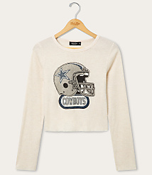 A cream-colored long-sleeved shirt with a graphic of a Dallas Cowboys helmet is displayed on a hanger against a plain white background. carousel Product Image 1