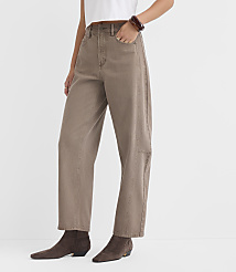 A person wearing loose-fitting tan pants and dark brown ankle boots stands against a plain white background. carousel Product Image 3