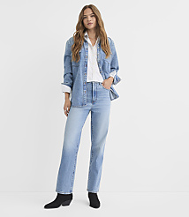 A woman in a denim shirt and jeans stands against a plain white background. carousel Product Image 1