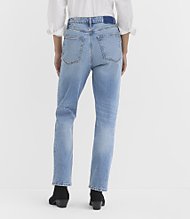A person wearing light-wash denim jeans and black boots stands against a plain white background. carousel Product Image 3