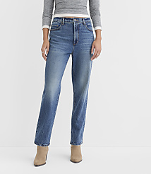 A person stands in the foreground wearing a grey long-sleeved shirt and blue jeans, with a plain white background behind them. carousel Product Image 2