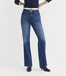 A person wearing blue flared jeans and black heeled boots stands against a plain white background. carousel Product Image 1