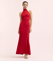 A woman in a red halter gown stands against a soft pink background. carousel Product Image 2