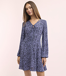 A woman in a blue floral dress stands against a soft pink background. carousel Product Image 2