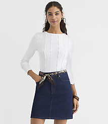 A woman in a white ribbed top and denim skirt stands against a plain white background. carousel Product Image 1
