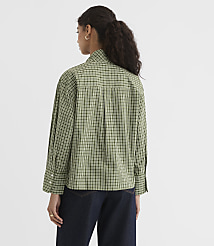 A woman in a green checkered shirt and dark jeans stands against a plain white background. carousel Product Image 4