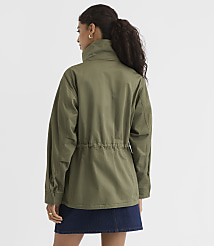 A woman in a green jacket and denim skirt stands against a plain white background. carousel Product Image 4