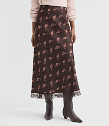 A woman in a floral print midi skirt and brown boots stands against a plain white background. carousel Product Image 3