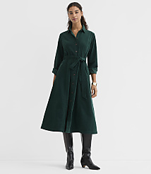 A woman in a green corduroy dress and black boots stands against a plain white background. carousel Product Image 1