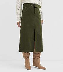 A person stands wearing a green corduroy skirt with a slit and a white patterned sweater, with tan boots peeking out from beneath the skirt, against a plain white background. carousel Product Image 2