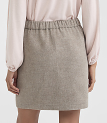A person in a light pink blouse and a textured brown mini skirt stands against a plain white background. carousel Product Image 3