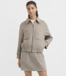 A woman in a beige jacket and skirt stands against a plain white background. carousel Product Image 2