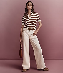 A woman in a striped polo shirt and wide-leg pants stands against a muted pink background. carousel Product Image 4