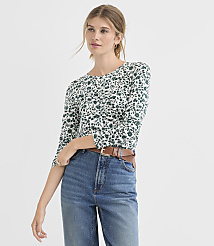 A woman in a floral top and jeans stands against a plain white background. carousel Product Image 1