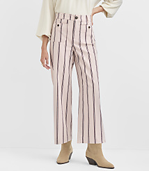 A person stands in front of a plain white background, wearing high-waisted pink and black striped pants and tan ankle boots. carousel Product Image 2