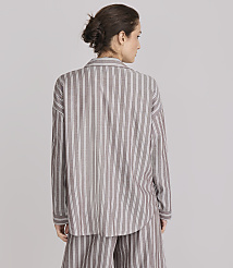 A woman in a striped pajama set stands against a plain gray background. carousel Product Image 3