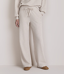 A person stands in light-colored lounge pants and slippers against a plain, light-colored background. carousel Product Image 2