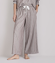 A person stands in striped pajama pants with their hands in their pockets against a plain background. carousel Product Image 2