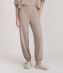 A person stands in beige loungewear and slippers against a plain white background. carousel Product Image 2
