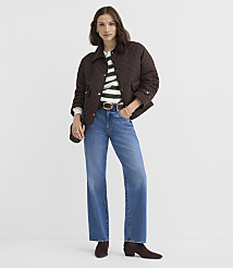 A woman in a quilted brown jacket, striped sweater, and wide-leg jeans stands against a plain gray background. carousel Product Image 2
