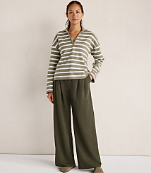 A woman in a striped collared shirt and wide-leg pants stands against a textured white background. carousel Product Image 2