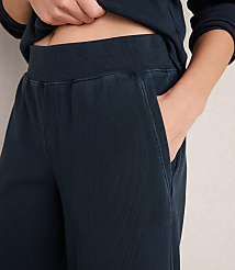 A person's hands are tucked into the pockets of dark blue ribbed sweatpants, with the waistband and a portion of a matching sweatshirt visible in the background. carousel Product Image 3