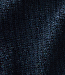 A close-up view of dark blue knitted fabric fills the frame, with subtle shadows and highlights creating depth in the textured background. carousel Product Image 3