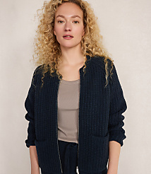 A woman with curly blonde hair wears a dark blue zippered cardigan over a taupe tank top, standing against a plain, light-colored background. carousel Product Image 1
