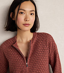 A young woman with short dark hair wears a textured rose-colored zip-up cardigan against a plain, light-colored background. carousel Product Image 2