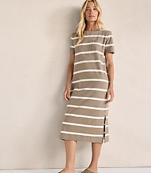 A blonde woman in a striped dress stands against a plain, textured wall. carousel Product Image 1
