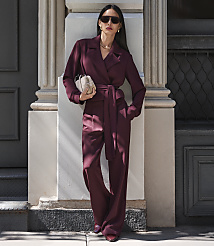 A woman in a burgundy jumpsuit stands against a building with a column and a dark door. carousel Product Image 6