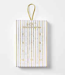 A white and gold striped advent calendar with "LOFT 12 DAYS OF GIFTING" printed on the front hangs against a plain white background. carousel Product Image 1