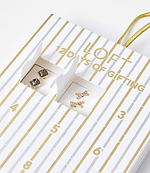 Two pairs of small, gold-toned earrings are visible in open compartments of a striped "12 Days of Gifting" advent calendar. carousel Product Image 3