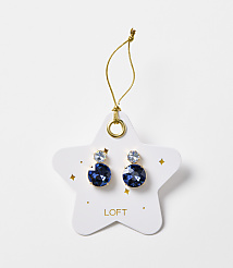 A pair of blue gem earrings are displayed on a white star-shaped card with gold accents and the "LOFT" logo, against a plain white background. carousel Product Image 1