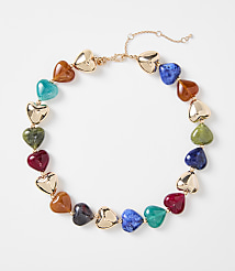 A colorful heart-shaped beaded necklace with gold accents rests on a plain white background. carousel Product Image 1