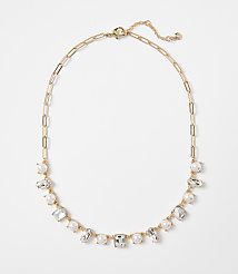 A gold chain necklace with alternating pearls and clear rectangular gems is displayed against a plain white background. carousel Product Image 1