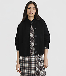 A woman in a black cardigan and plaid dress stands against a plain white background. carousel Product Image 1