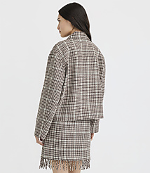 A woman in a plaid jacket and skirt with fringe stands against a plain white background. carousel Product Image 3