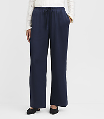 A person wearing navy blue wide-leg pants and a white sweater stands against a plain white background. carousel Product Image 2