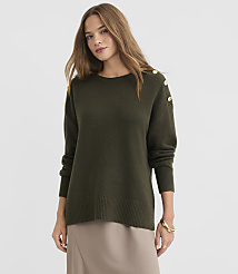 A woman in a green sweater with gold buttons stands against a plain background. carousel Product Image 1