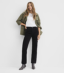 A woman in a white lace top, olive green jacket, and black corduroy pants stands against a plain white background. carousel Product Image 1