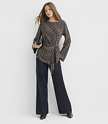 A woman in a plaid top and wide-leg jeans stands against a plain white background. carousel Product Image 1